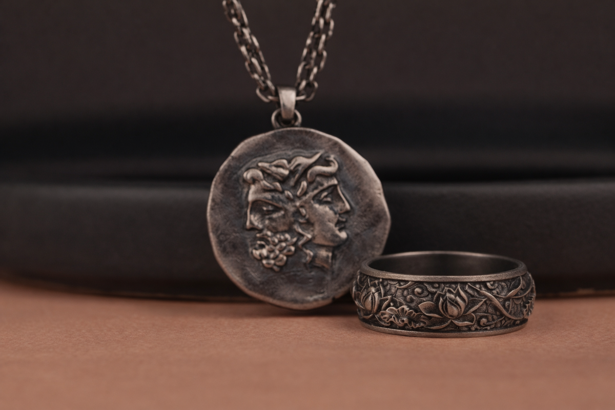 oxidized janus coin necklace and lotus ring symbolizing new beginnings