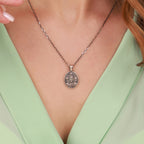 Necklace with a jesus pendant worn by a person in a green top