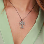 An oxidized sterling silver armenian cross pendant necklace on a person wearing a light green top