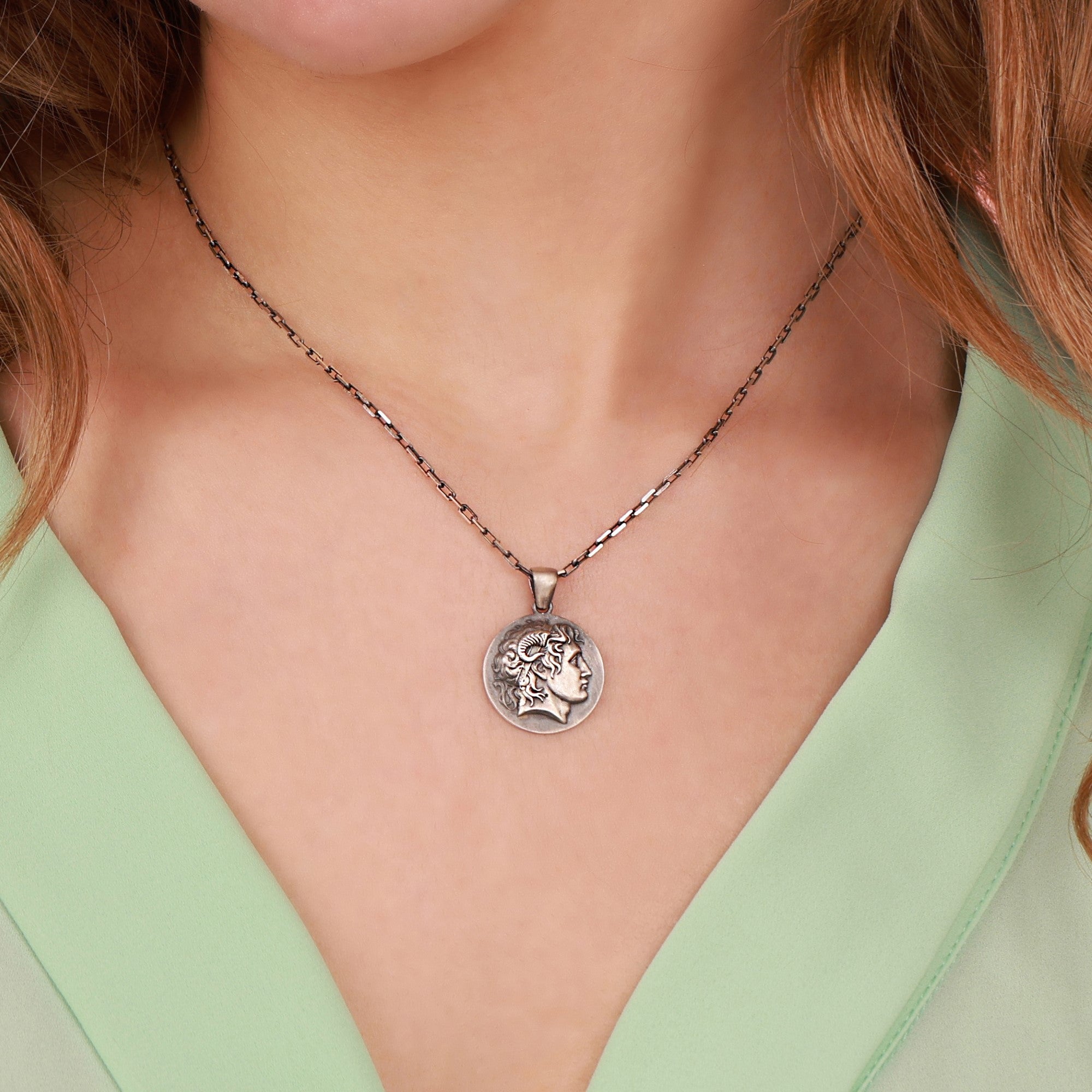 An oxidized Alexander the Great coin necklace worn by women with green