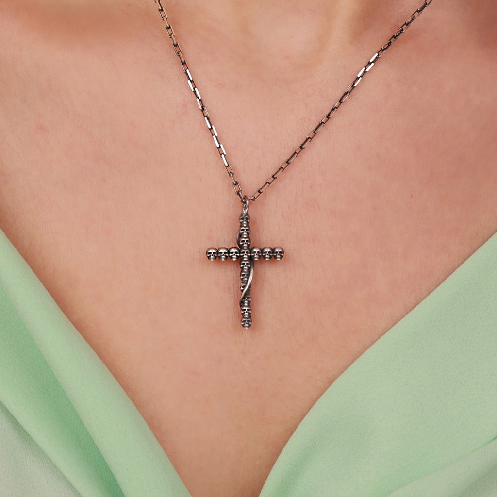 Sterling Silver gothic cross necklace on a person wearing a light green top