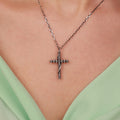 Sterling Silver gothic cross necklace on a person wearing a light green top