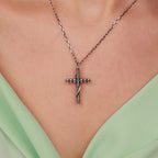 Sterling Silver gothic cross necklace on a person wearing a light green top