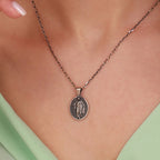 Necklace with a risen jesus pendant on a person wearing a light green top