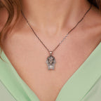 Necklace with a Pharaoh head pendant worn by a person in a green top.
