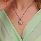 Necklace with an athena pendant worn by a person in a light green top