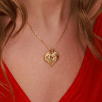 A gold two-horse in a heart-shaped necklace worn by a person with red clothing