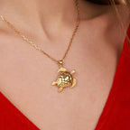 Gold vermeil sea turtle pendant necklace on a person wearing a red top
