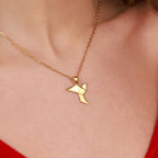 Close-up of a gold vermeil dove pendant necklace on a model