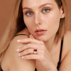 A woman wearing a red ruby wide band ring