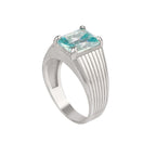 Silver ring with a central icy blue gemstone on a white background