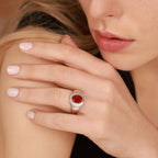 Woman wearing a ring with a red stone on her hand