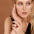 Woman with blonde hair and a red ring on a brown background