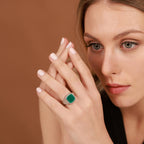 Woman wearing a green agate ring on a brown background