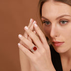 Woman wearing a red agate ring on a brown background