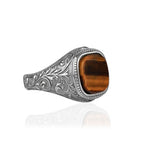 Silver ring with a cushion cut brown stone on a white background