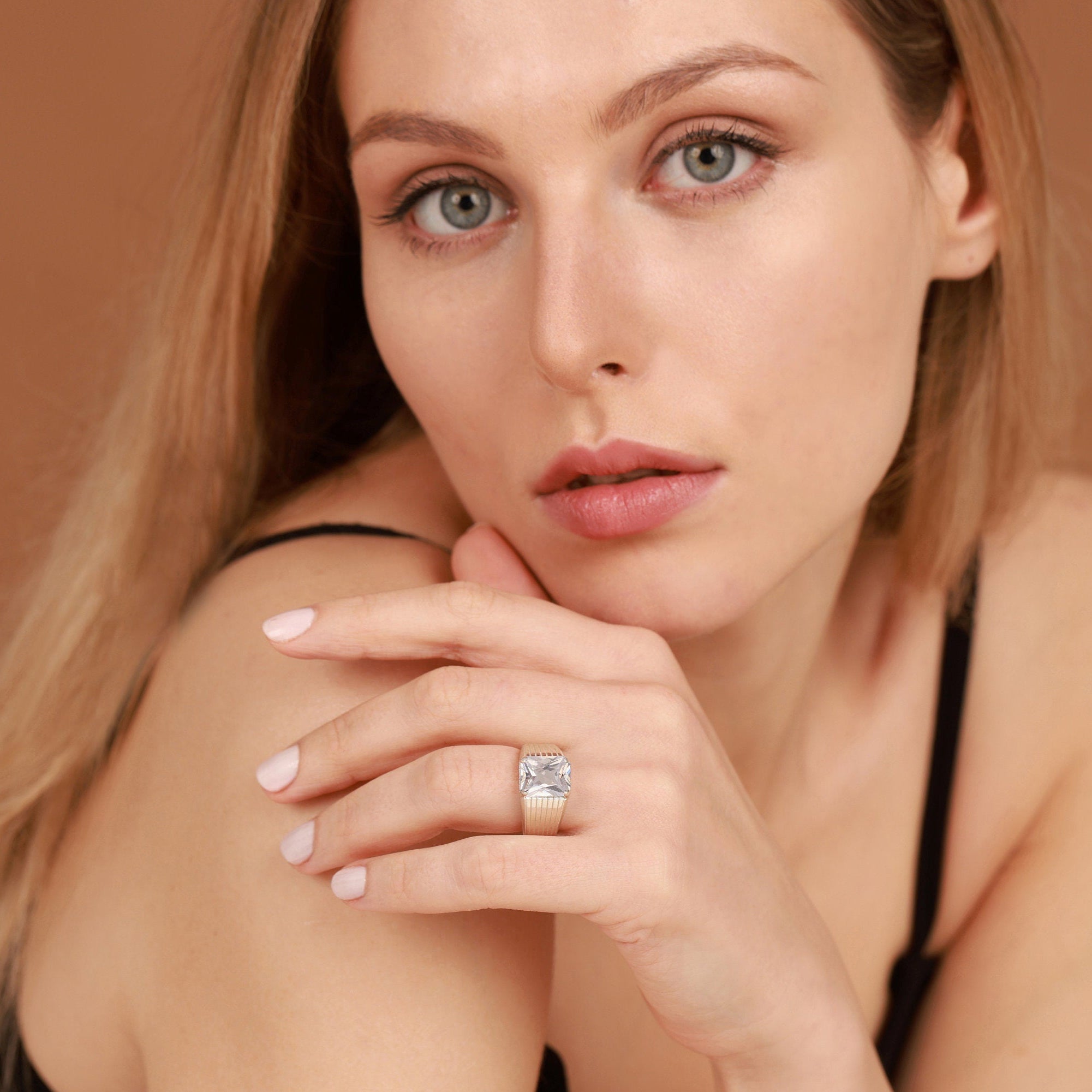 Woman wearing a diamond ring on a brown background