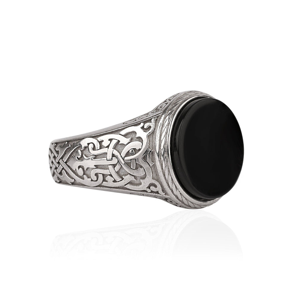 Silver ring with Celtic patterns on a white background