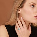 Woman wearing a blue topaz gemstone ring on a brown background