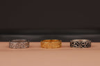 gold, polished and oxidized three-band rings on beige and black background