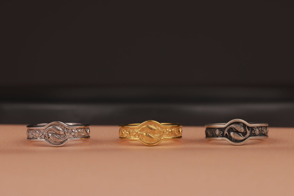 Three rings of different designs on a brown surface with a dark background
