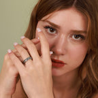 Woman with a ring on her finger against a green background