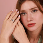 Woman wearing a polished tree of life ring with a pink background