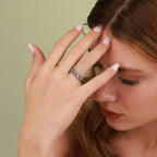 Woman wearing a gothic ring with a green background