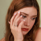 A woman wearing a oxidized silver ring with a green background