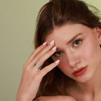 Woman with oxidized vintage wedding band ring on face against a green background