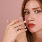 Woman wearing a silver ring on a pink background
