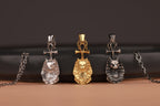 Four cat-shaped pendants on chains against a dark background