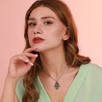 A woman wearing an oxidized silver necklace with a hamsa hand pendant