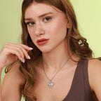 Woman wearing a elephant necklace against a light green background