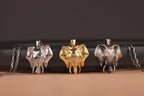 Three elephant-shaped pendants in different colors on a dark background
