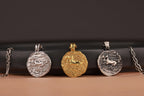 Four pendants on chains against a dark background