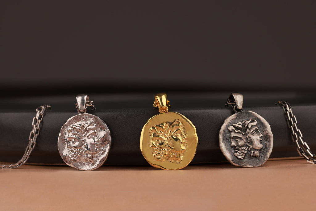 Three pendant necklaces on a black and brown gradient background