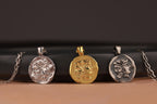 Three pendant necklaces on a black and brown gradient background