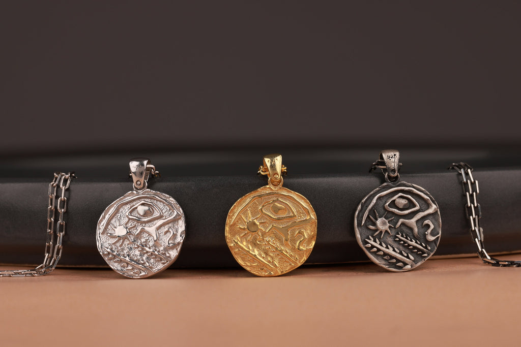 Four silver pendants on a dark background