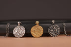 Four silver pendants on a dark background