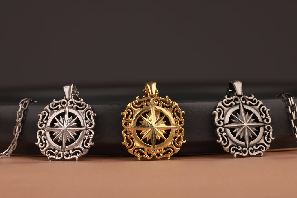 Three compass-themed North Star pendants on a black and brown gradient background