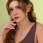 Woman wearing a polished silver North Star necklace with a green background