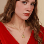 Woman wearing a gold north star necklace with a red top against a beige background