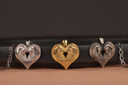 Three horse couple heart-shaped pendants in silver, gold, and bronze on a dark background