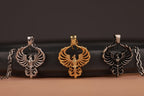 Three firebird-shaped pendants in silver, gold, and bronze on a dark surface.