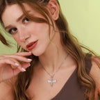 Woman wearing a silver necklace with a isis pendant against a green background
