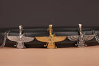 Three-winged figure pendants on a black background