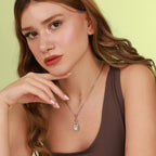 Woman wearing a necklace with a cat-shaped pendant against a light green background