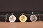Four pendants on chains with Athena owl designs against a dark background