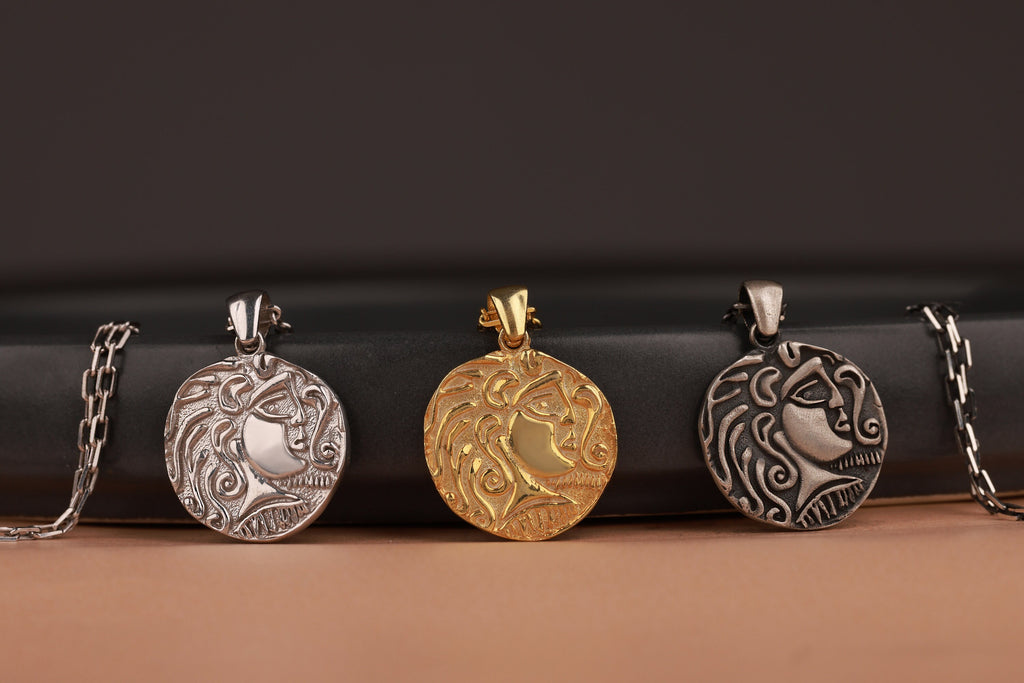 Four ancient silver and gold pendants on a dark surface